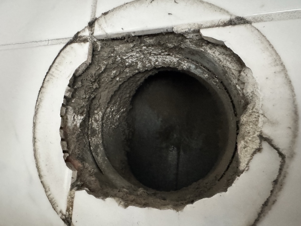 Vervuilde ventilatie-opening met dikke stoflaag