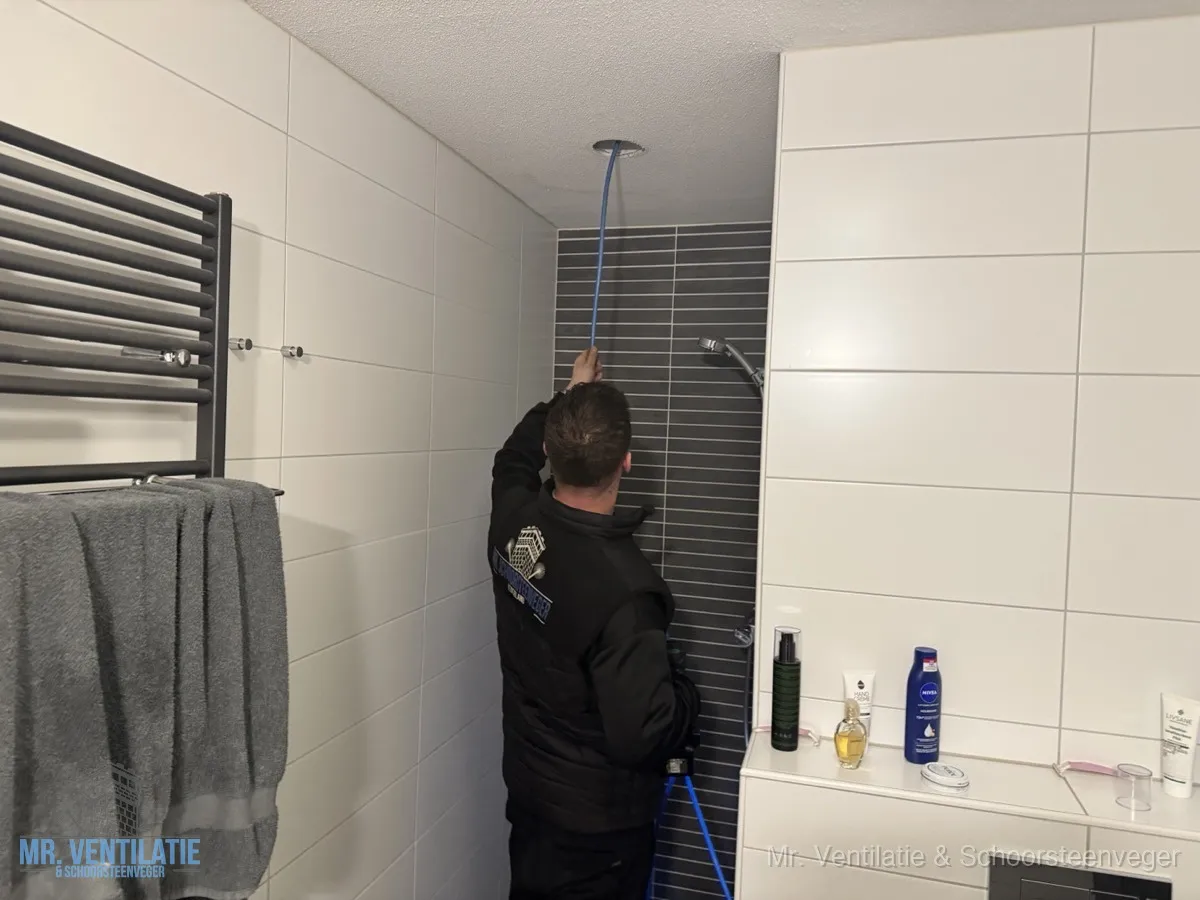 Monteur reinigt ventilatiekanaal in badkamer